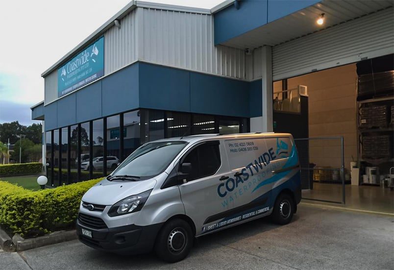 A Van in Front of a Store — Internal Waterproofing in Central Coast, NSW